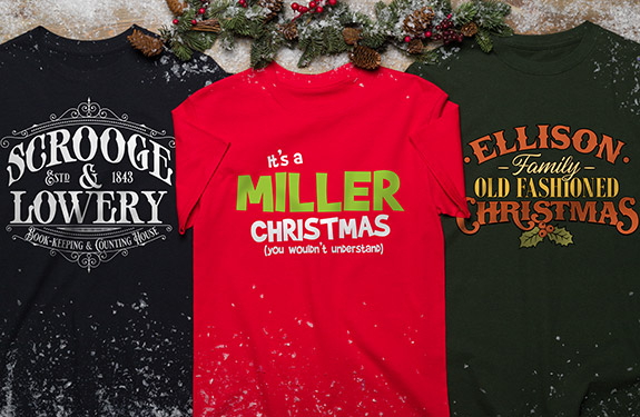 three t-shirts shirts, laid flat: navy, red, and green, with personalized Christmas slogans